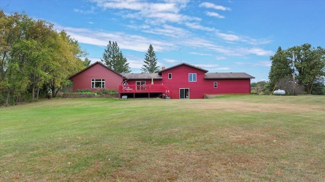 rear view of house featuring a yard and a wooden deck