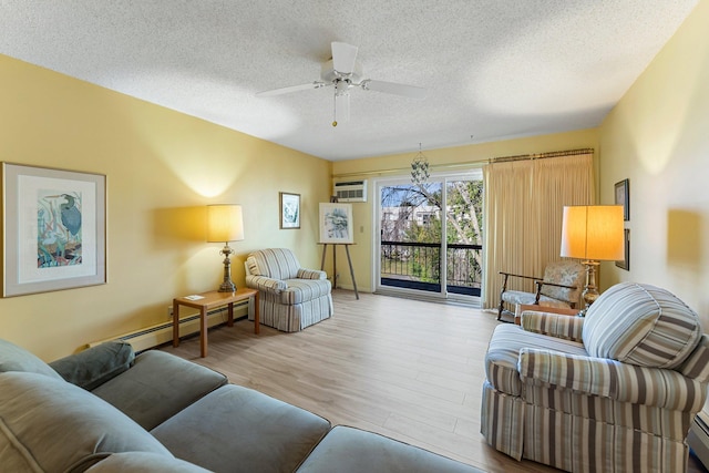 living area with a baseboard heating unit, a ceiling fan, an AC wall unit, a textured ceiling, and wood finished floors