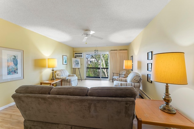 living room featuring a baseboard radiator, ceiling fan, a textured ceiling, light wood-type flooring, and baseboards