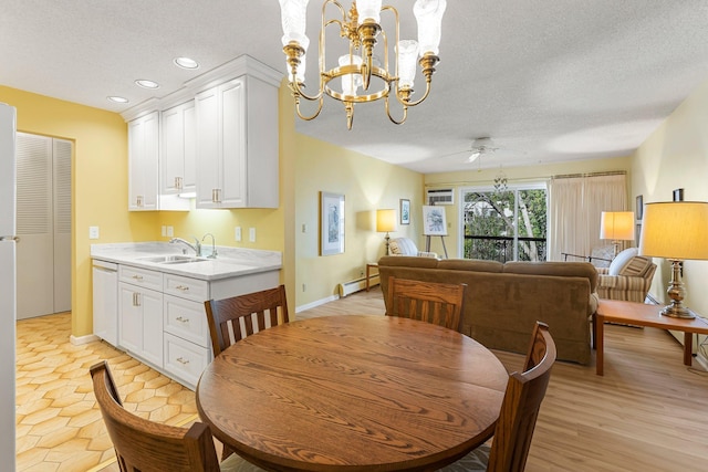 dining area with a ceiling fan, a baseboard radiator, light wood-style flooring, a textured ceiling, and recessed lighting