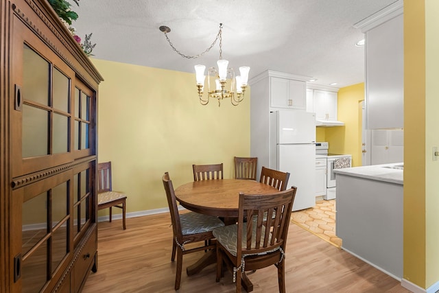 dining area featuring recessed lighting, baseboards, light wood finished floors, and an inviting chandelier