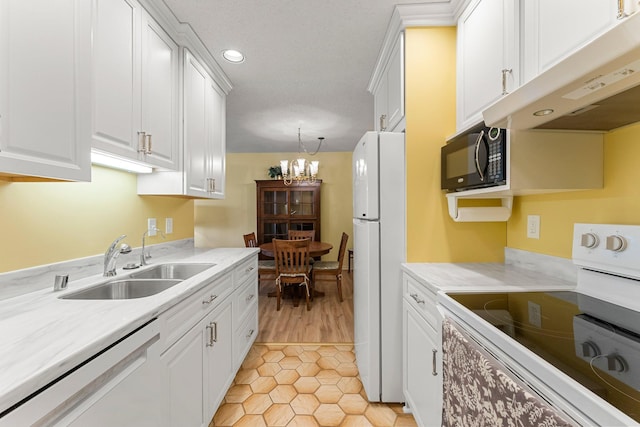 kitchen with light countertops, white cabinetry, a sink, white appliances, and under cabinet range hood