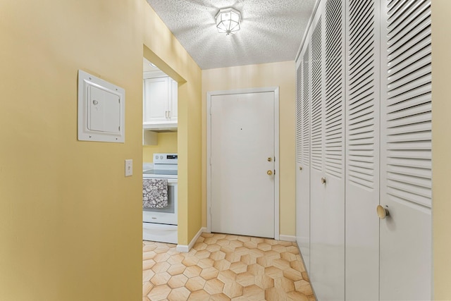 interior space featuring a textured ceiling, light tile patterned floors, and baseboards