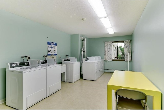 community laundry room with light floors, washing machine and dryer, and a textured ceiling