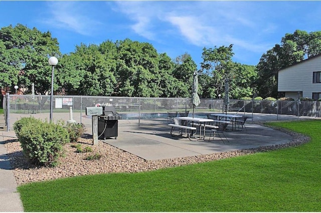 view of property's community with a yard, a patio area, and fence