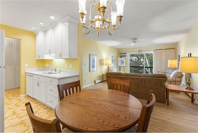 dining space featuring light wood finished floors, a baseboard radiator, recessed lighting, a textured ceiling, and baseboards