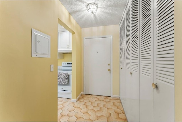 interior space with light tile patterned floors, baseboards, and a textured ceiling