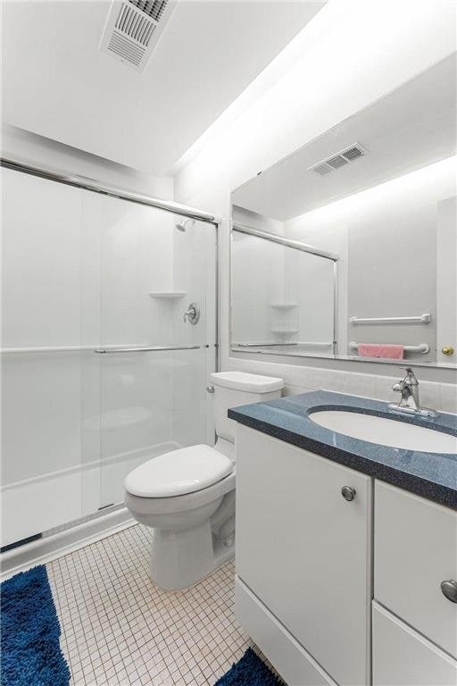 bathroom featuring a stall shower and visible vents