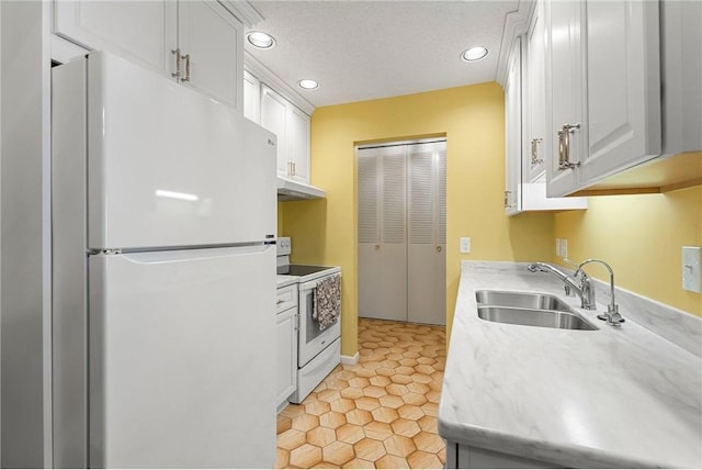 kitchen with a textured ceiling, white appliances, a sink, white cabinetry, and light countertops