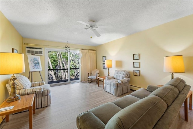 living room featuring a ceiling fan, wood finished floors, a textured ceiling, an AC wall unit, and a baseboard heating unit