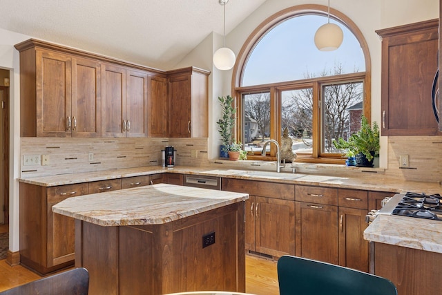 kitchen featuring decorative backsplash, lofted ceiling, plenty of natural light, and a sink