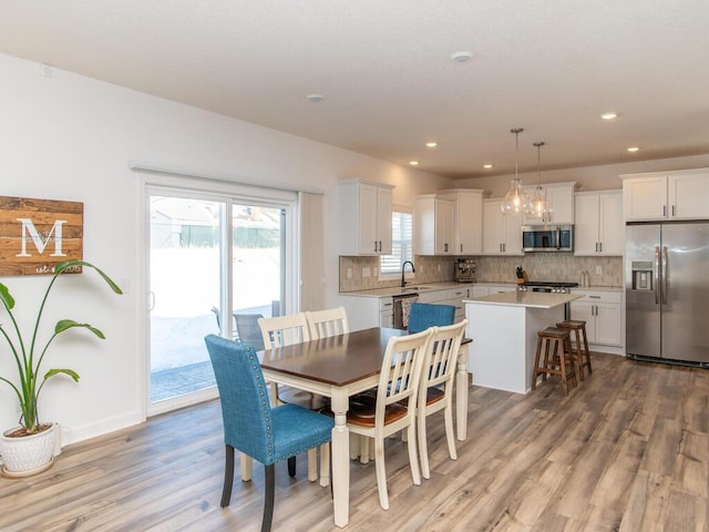 dining room featuring light wood-type flooring, baseboards, and recessed lighting