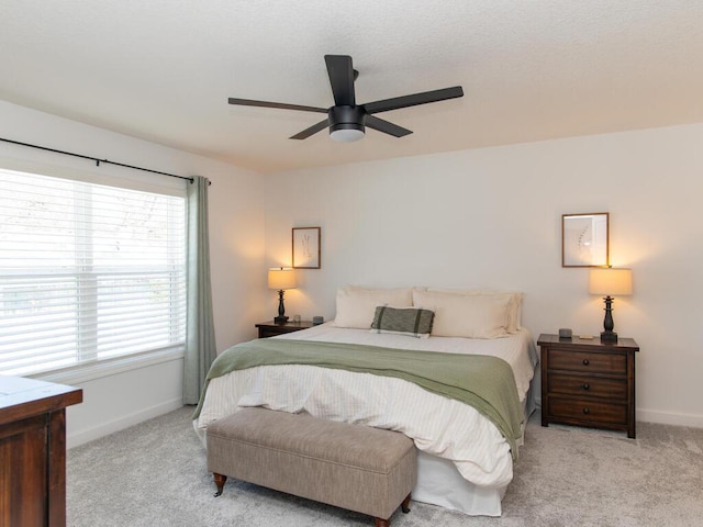 carpeted bedroom featuring baseboards and a ceiling fan