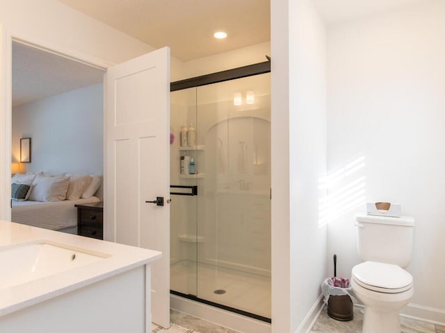 ensuite bathroom featuring baseboards, toilet, ensuite bath, vanity, and a shower stall