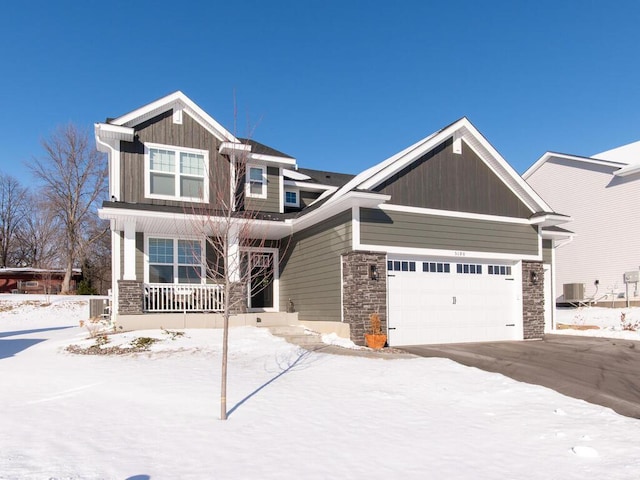 craftsman house featuring a garage, covered porch, and stone siding