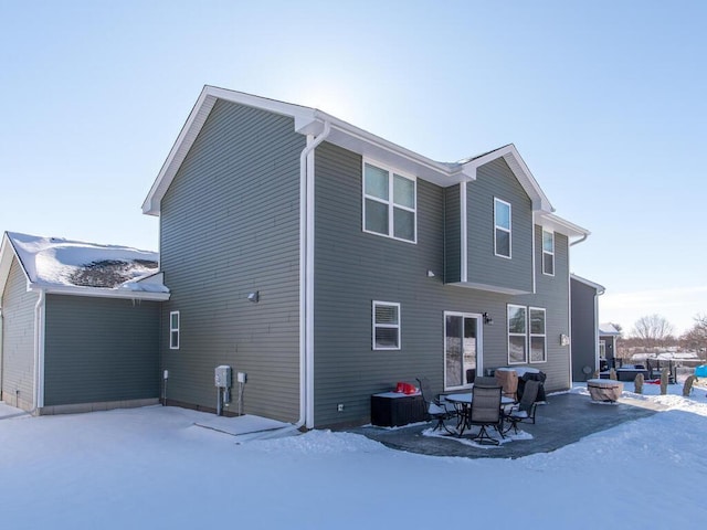 snow covered property with a patio