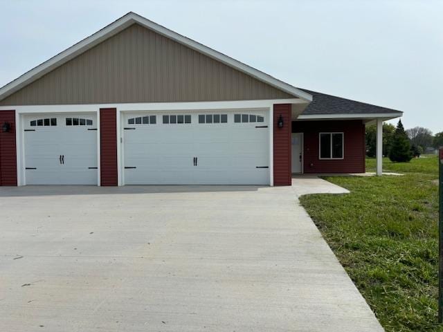 single story home with a shingled roof, a front yard, driveway, and an attached garage