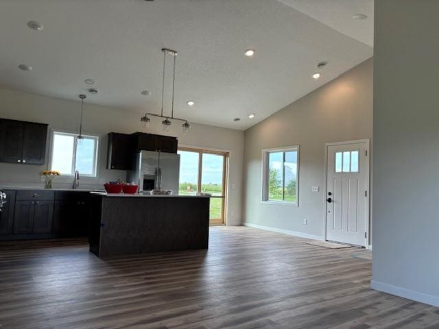 kitchen with plenty of natural light, wood finished floors, stainless steel refrigerator with ice dispenser, and a kitchen island