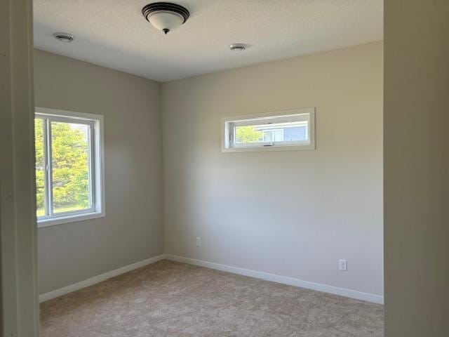 unfurnished room with light carpet and baseboards