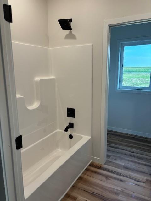 full bathroom with  shower combination, baseboards, and wood finished floors