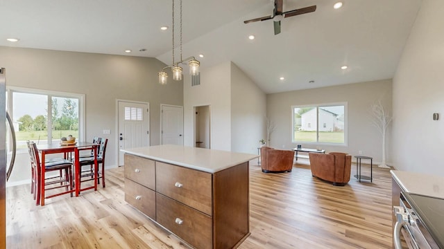 619 6th St, West Concord, MN 55985 - kitchen featuring stainless steel stove, light wood-type flooring, high vaulted ceiling, a center island, and ceiling fan