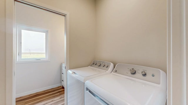 619 6th St, West Concord, MN 55985 - laundry room with washing machine and dryer, light wood-type flooring, and baseboards