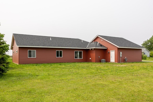619 6th St, West Concord, MN 55985 - rear view of house with central AC unit, a lawn, and roof with shingles