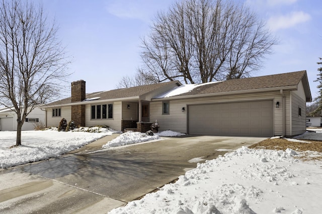 ranch-style home with an attached garage, driveway, and a chimney