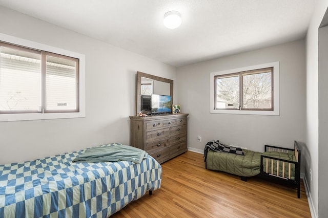 bedroom featuring light wood-style floors and baseboards