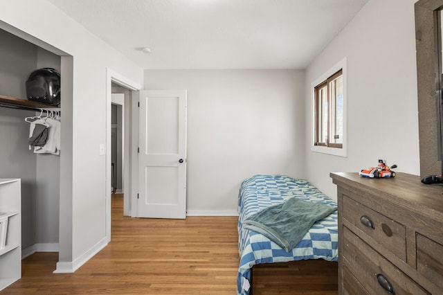 bedroom featuring baseboards and light wood finished floors