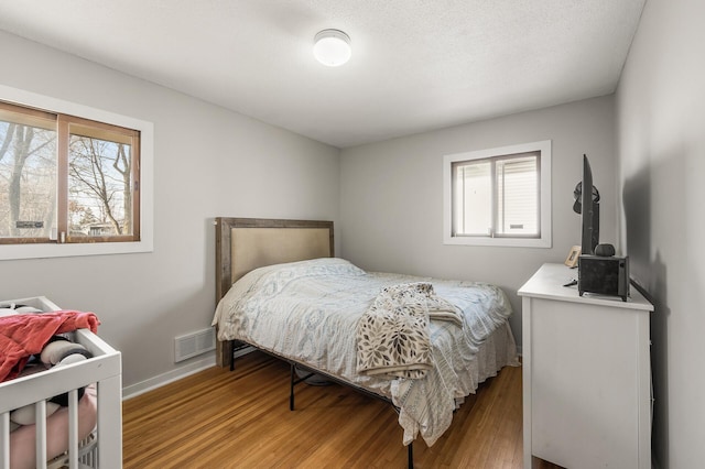 bedroom featuring light wood-style flooring, baseboards, and visible vents