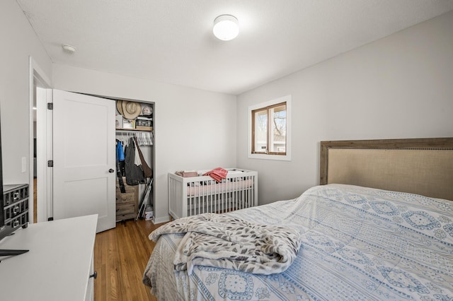 bedroom with wood finished floors and a closet