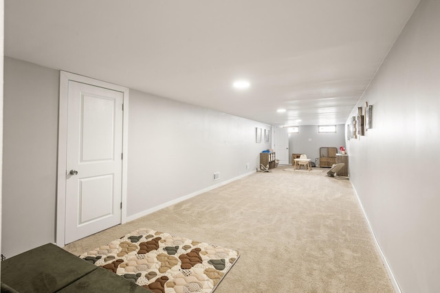 below grade area featuring baseboards and carpet