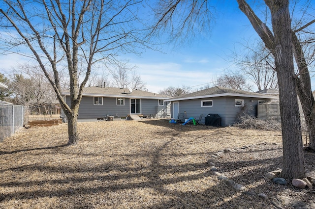 rear view of property with entry steps and fence