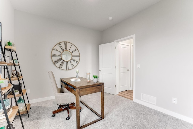 carpeted office featuring baseboards and visible vents