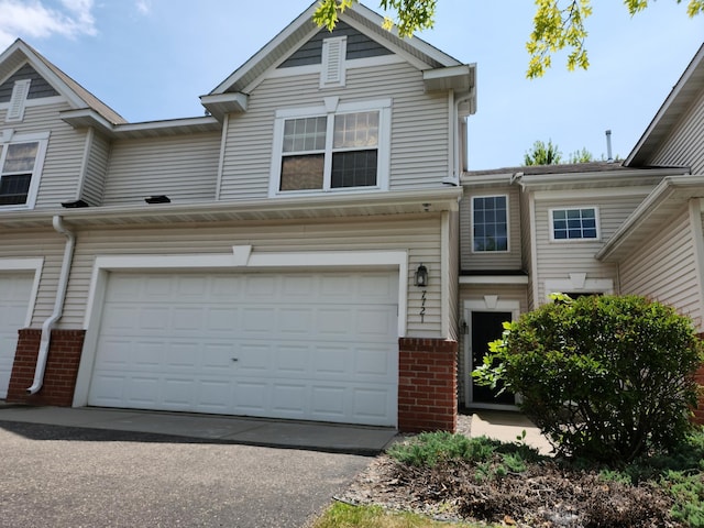 view of front of house with a garage, aphalt driveway, and brick siding