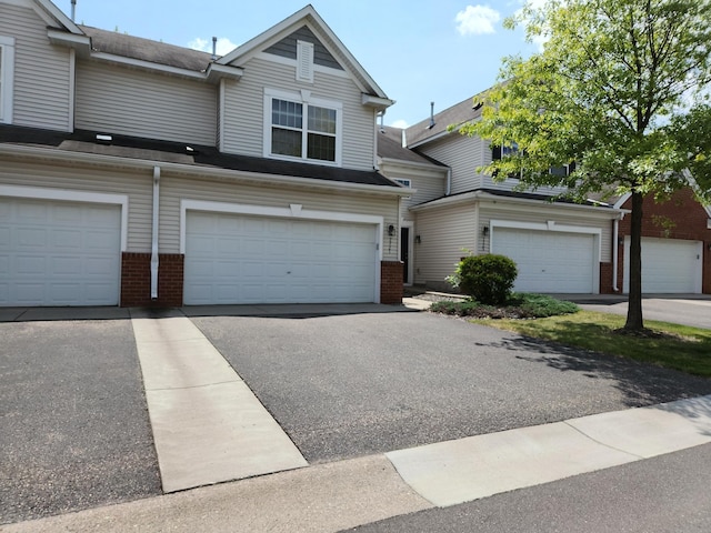 7721 Elm Grove Ave, New Hope, MN 55428 - view of front facade with brick siding, a garage, and asphalt driveway