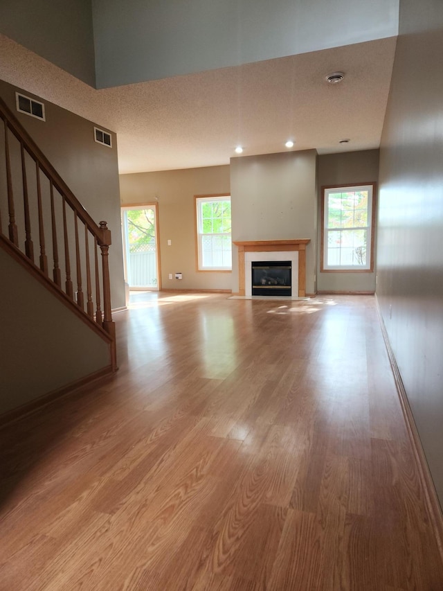 7721 Elm Grove Ave, New Hope, MN 55428 - unfurnished living room with a fireplace with flush hearth, wood finished floors, stairs, and baseboards