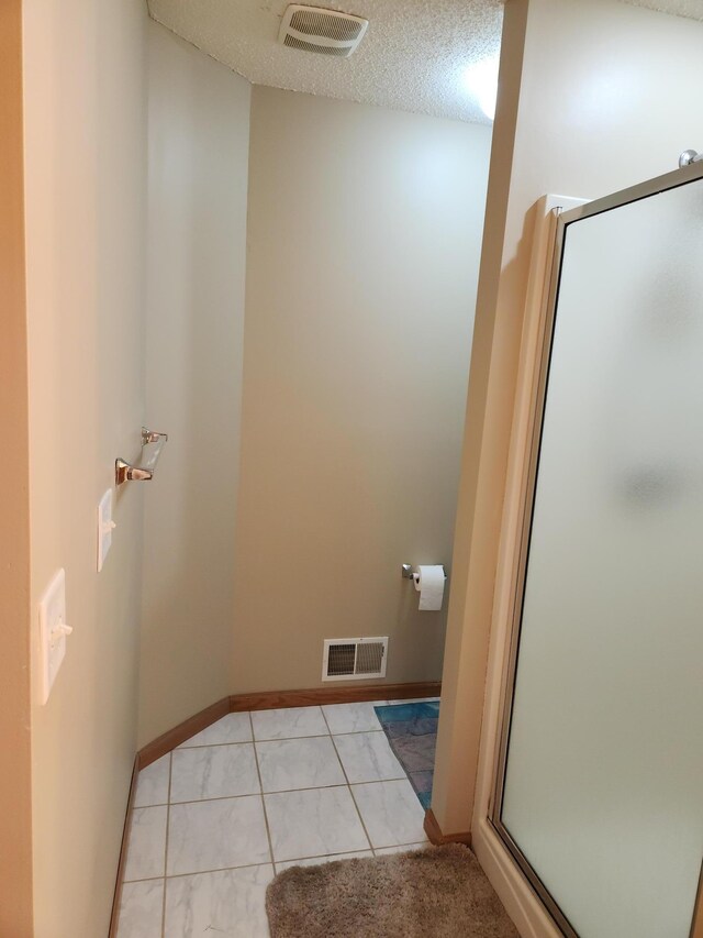 7721 Elm Grove Ave, New Hope, MN 55428 - full bathroom with a shower stall, tile patterned flooring, baseboards, and a textured ceiling