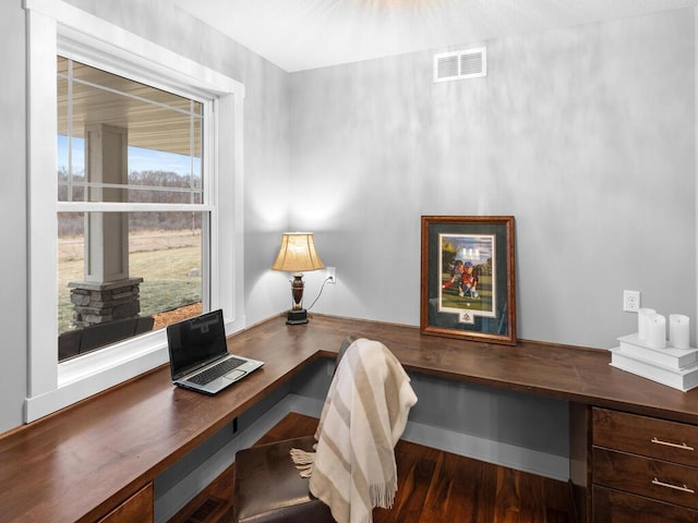 office featuring built in desk, wood finished floors, visible vents, and baseboards