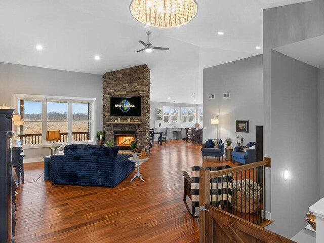 living room with visible vents, a ceiling fan, hardwood / wood-style floors, a fireplace, and high vaulted ceiling