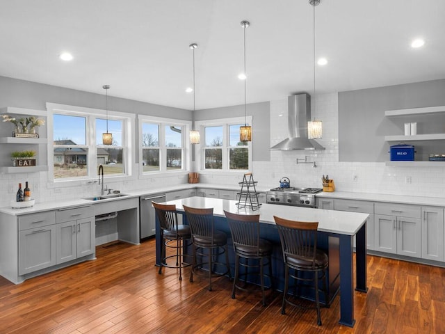 kitchen with dishwasher, wall chimney exhaust hood, a kitchen bar, open shelves, and a sink