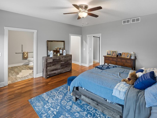 bedroom with a ceiling fan, connected bathroom, baseboards, and wood finished floors