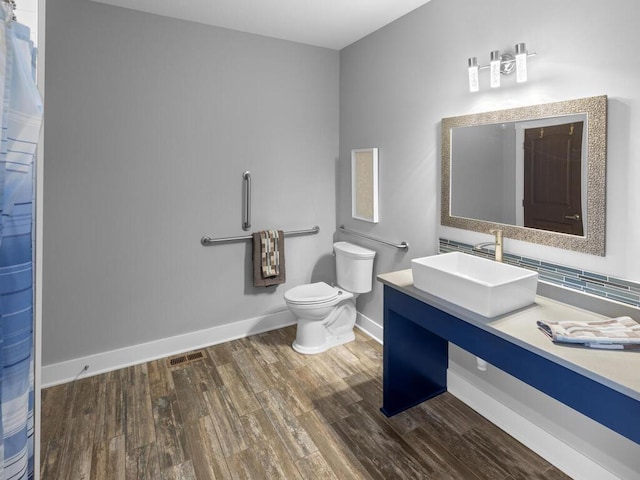 full bath featuring visible vents, baseboards, toilet, wood finished floors, and vanity