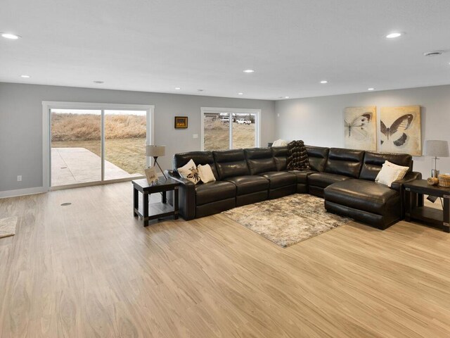 living room with baseboards, wood finished floors, and recessed lighting