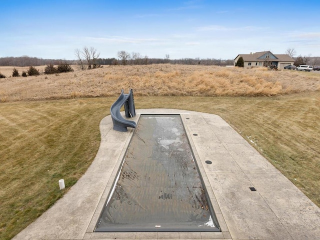 view of storm shelter with a yard and a rural view