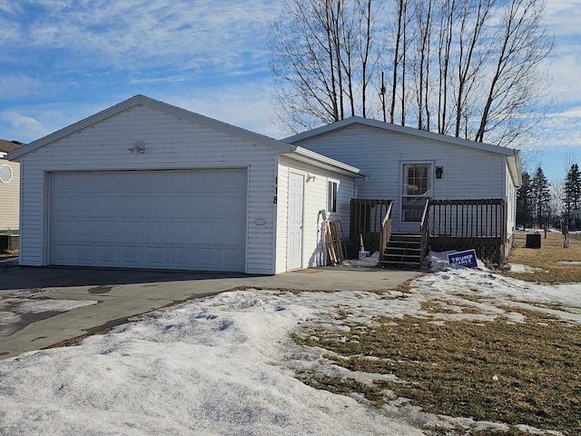 view of front facade featuring a garage, an outdoor structure, and central air condition unit