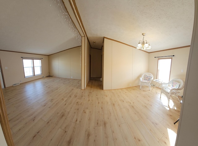 interior space featuring visible vents, a textured ceiling, crown molding, light wood-style floors, and a notable chandelier