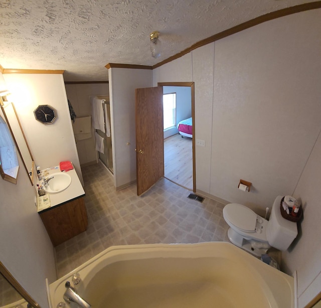 full bathroom featuring crown molding, visible vents, a bathing tub, a sink, and a textured ceiling