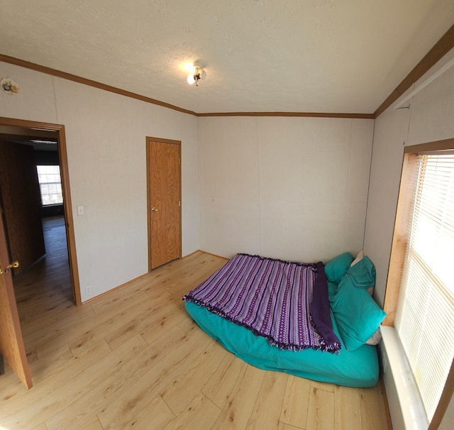 bedroom with ornamental molding, a closet, and wood finished floors